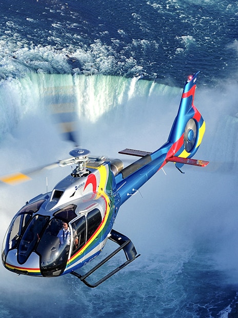 Helicopter flying over Niagara Falls during a scenic tour.