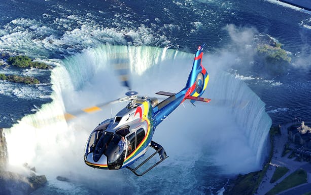 Helicopter flying over Niagara Falls during a scenic tour.