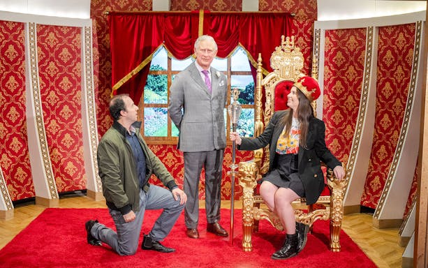 Wax figure of King Charles with visitors at Madame Tussauds Sydney.