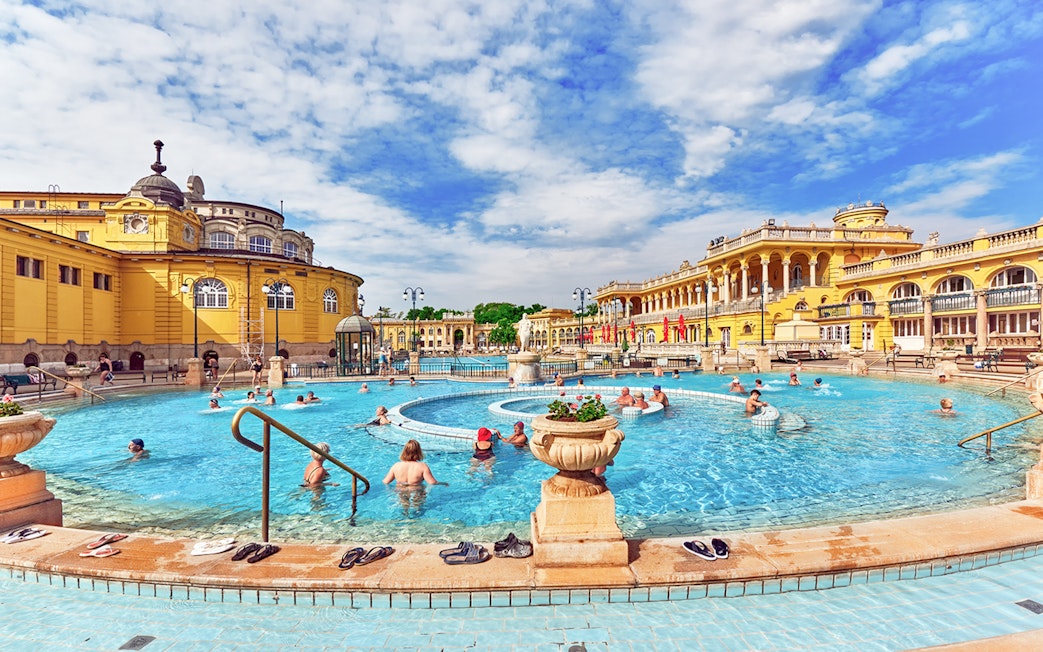 Visitors enjoying the thermal pool in the courtyard of Szechenyi Baths, Budapest.