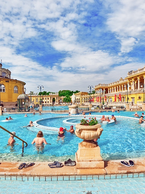 Visitors enjoying the thermal pool in the courtyard of Szechenyi Baths, Budapest.