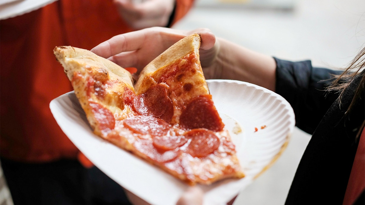 Freshly baked pizza slice on a New York street.