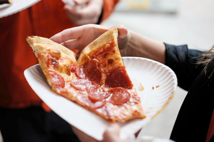 Freshly baked pizza slice on a New York street.