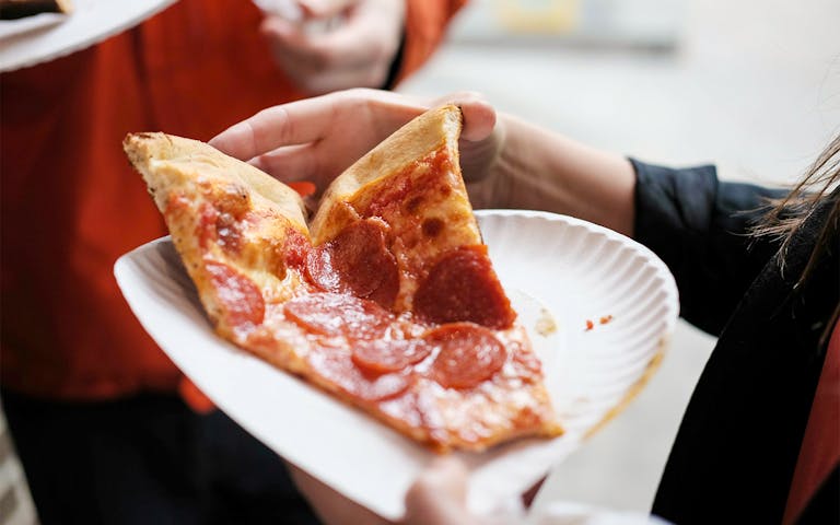 Freshly baked pizza slice on a New York street.