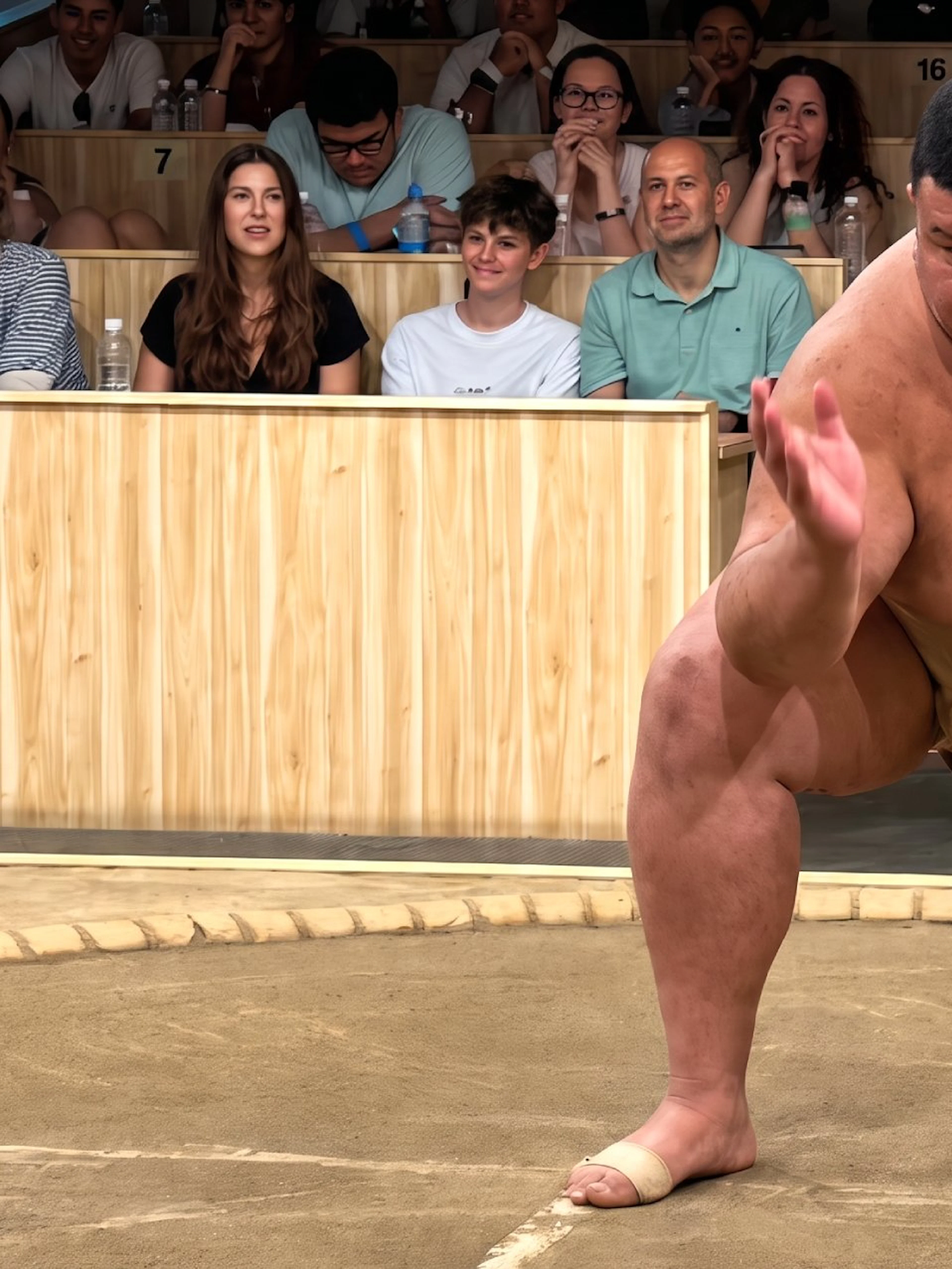 Sumo wrestler performing in front of an audience at a Kyoto live sumo show.
