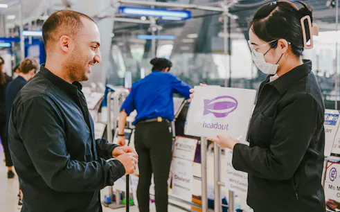 Headout representative greeting traveler at Suvarnabhumi Airport for private transfer.