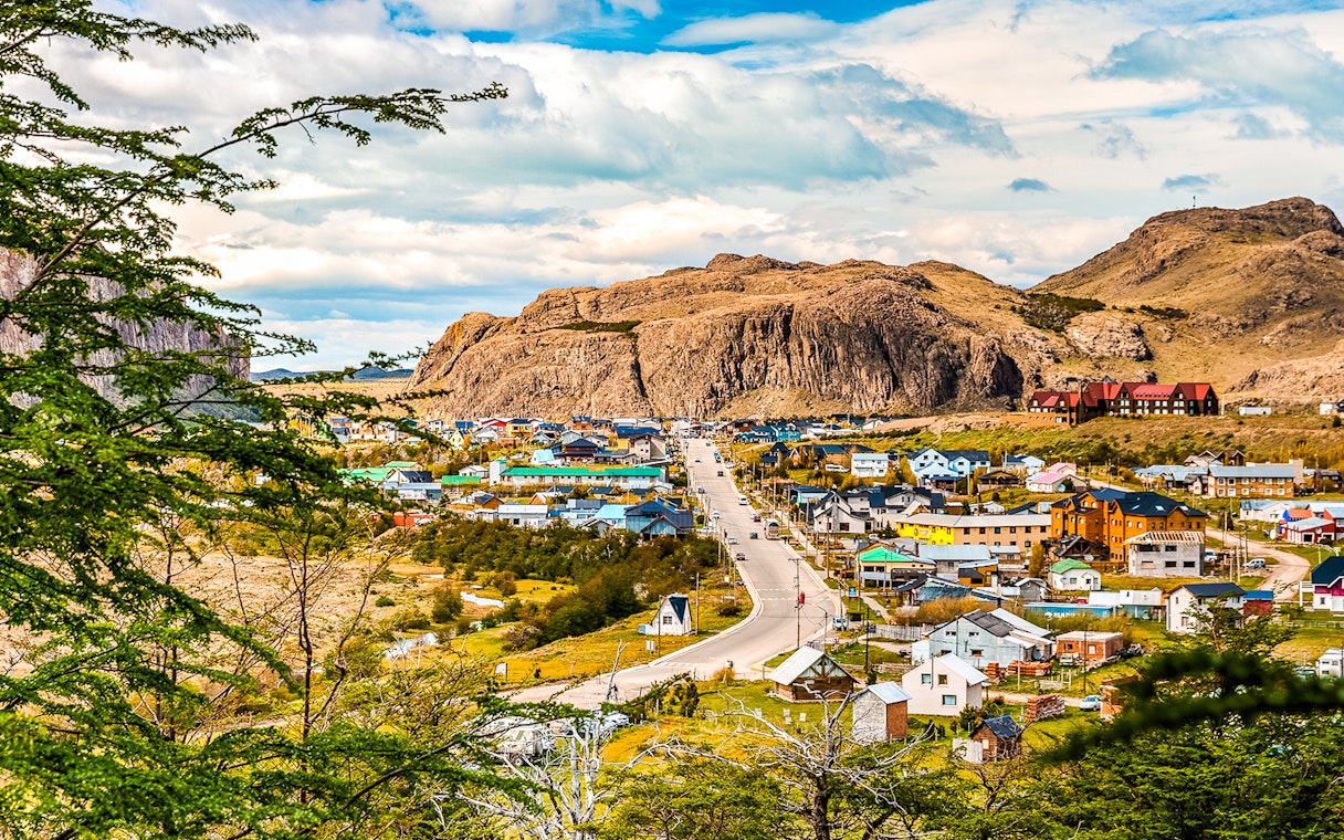 Aerial view of El Chaltén with colorful houses and Mount Fitz Roy in the background.