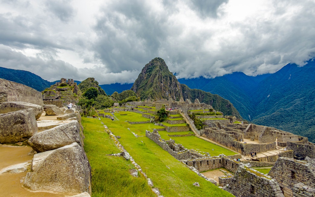 Stone structures and terraces at Machu Picchu with mountain backdrop.