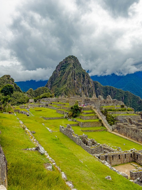Stone structures and terraces at Machu Picchu with mountain backdrop.