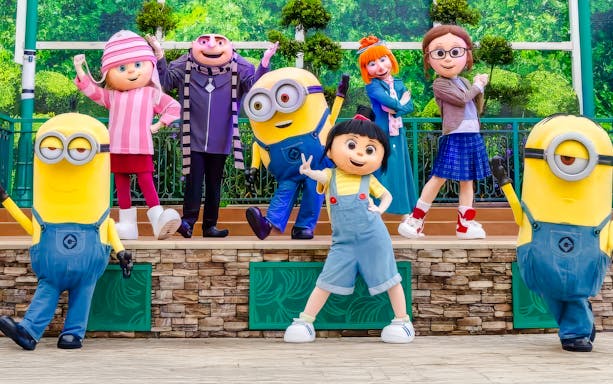 Gru, Lucy, the girls, and Minions posing together for a family photo at a theme park.