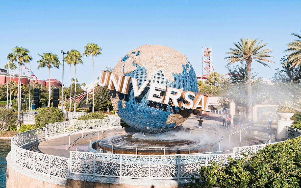 Universal globe at entrance of Universal Studios Resort, Orlando, Florida with palm trees.