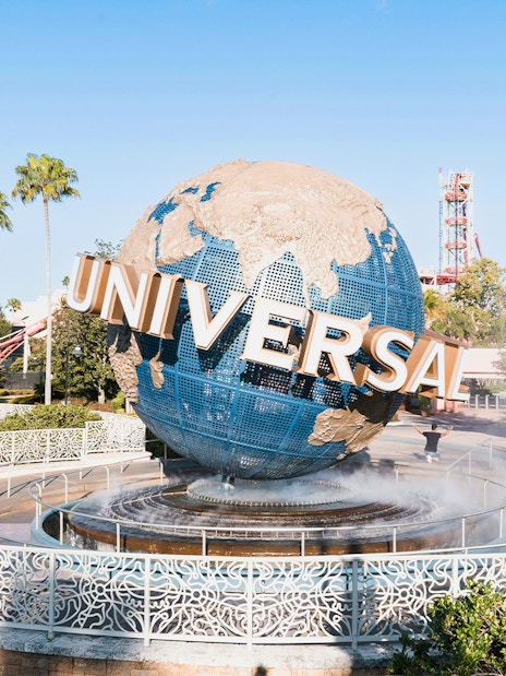 Universal globe at entrance of Universal Studios Resort, Orlando, Florida with palm trees.