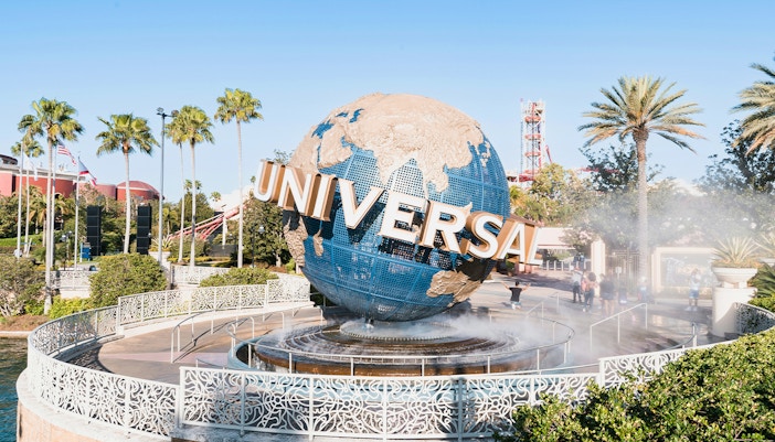 Universal globe at entrance of Universal Studios Resort, Orlando, Florida with palm trees.