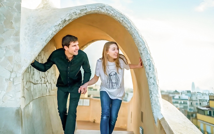 Couple exploring rooftop architecture on La Pedrera Fast Track Guided Tour in Barcelona.