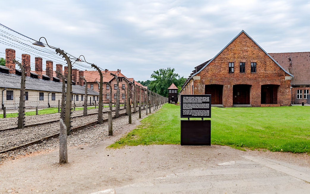 Auschwitz I barrack with barbed wire fence and informational sign, Auschwitz Birkenau.