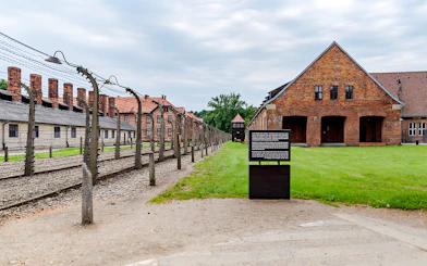 Auschwitz I barrack with barbed wire fence and informational sign, Auschwitz Birkenau.