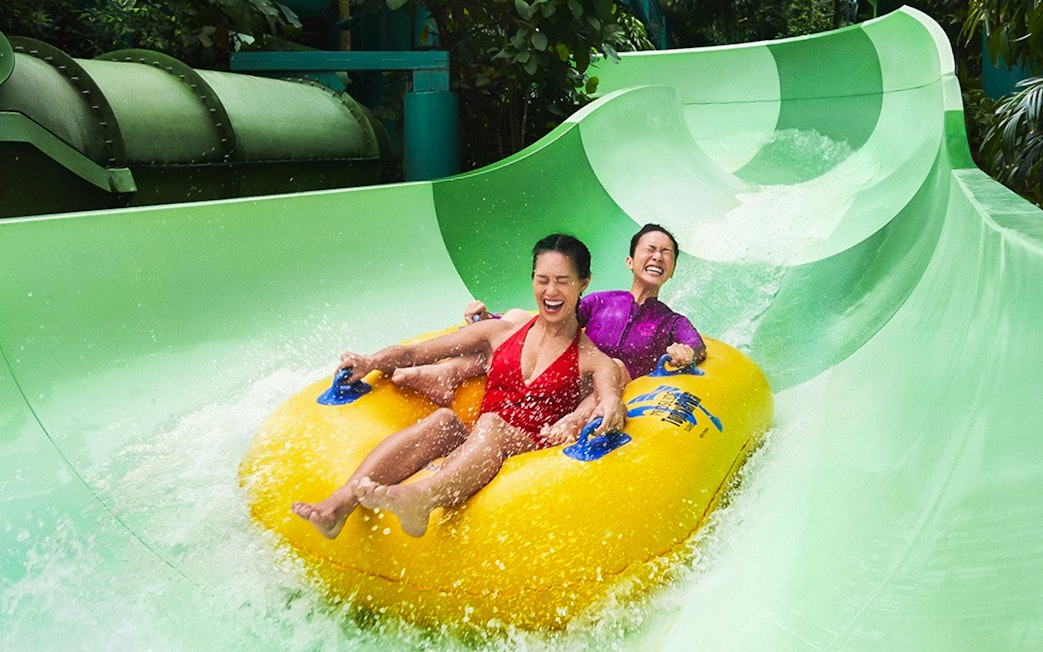Couple enjoying a waterslide ride at Adventure Cove Waterpark.