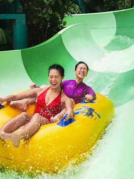Couple enjoying a waterslide ride at Adventure Cove Waterpark.