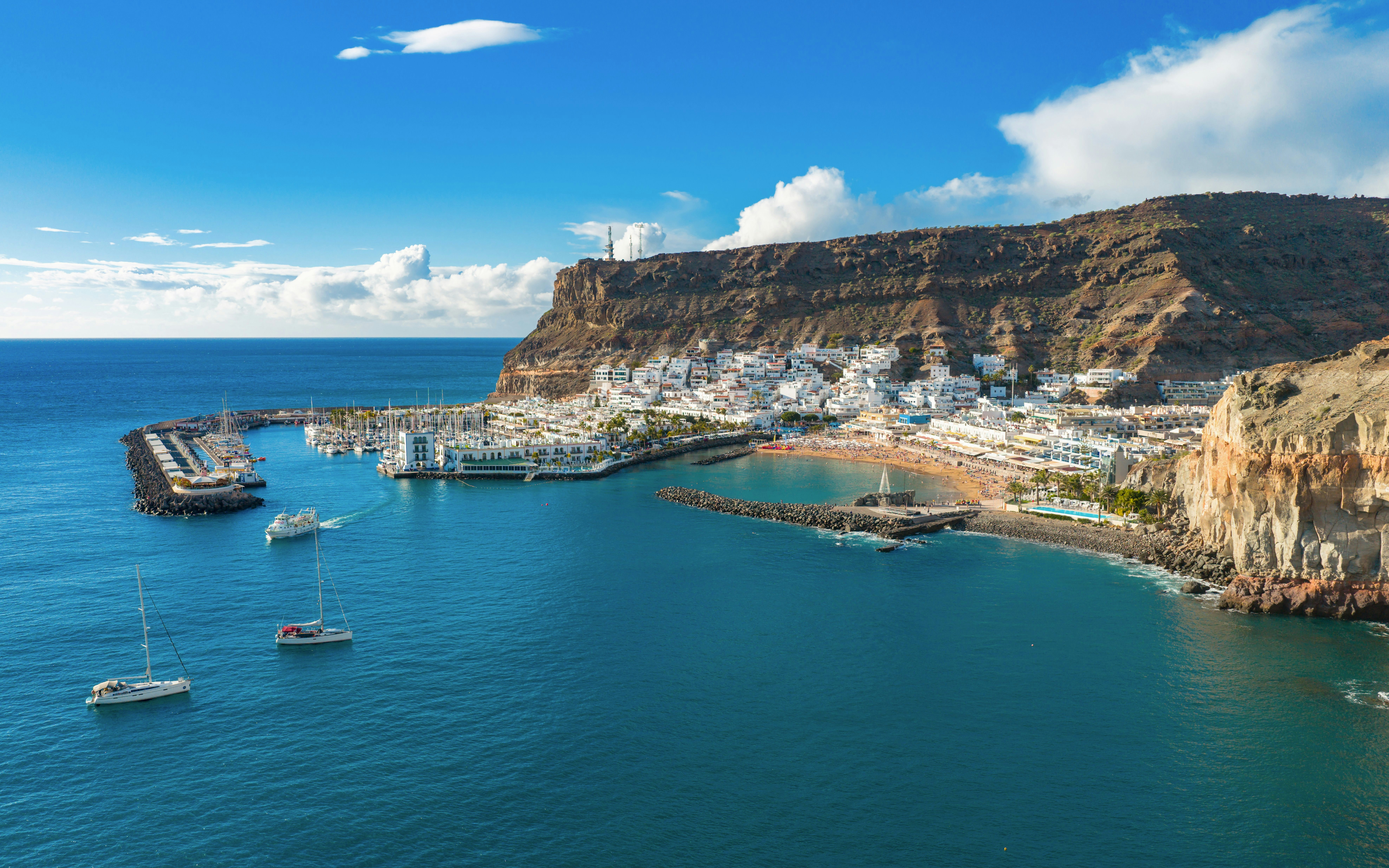 Puerto de Mogán Marina with sailboats and white village at sunset, Gran Canaria.