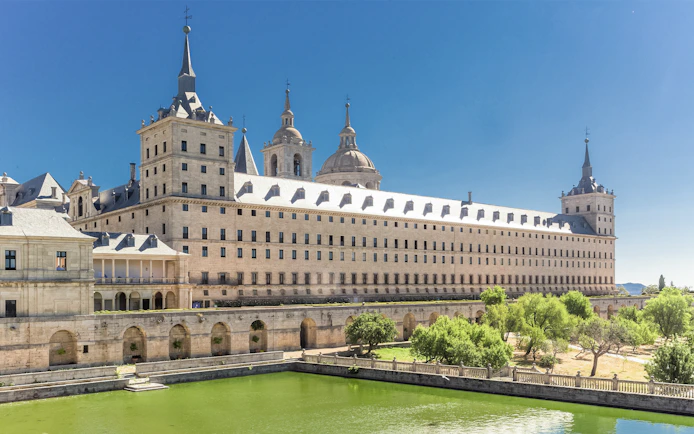 El Escorial Monastery in Spain with its grand architecture and surrounding greenery.
