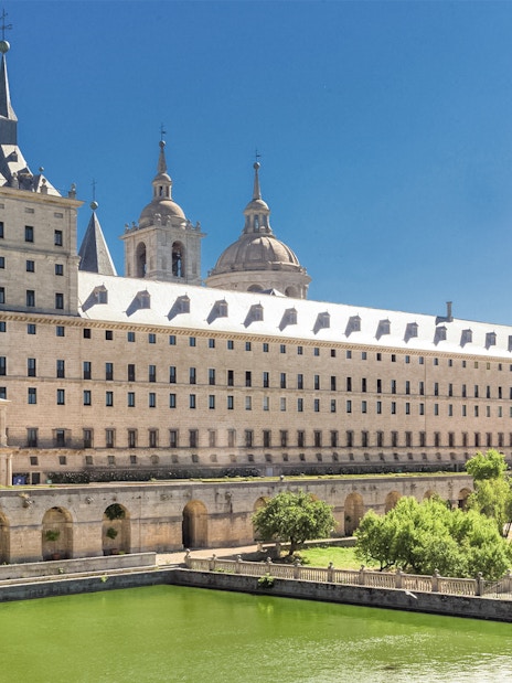 El Escorial Monastery in Spain with its grand architecture and surrounding greenery.