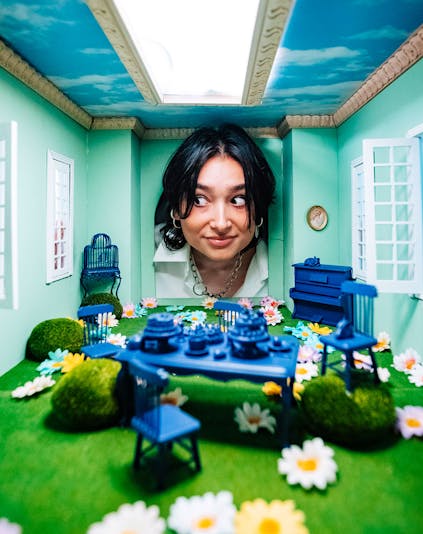 Studio of Wonders - a woman peeping into a miniature room