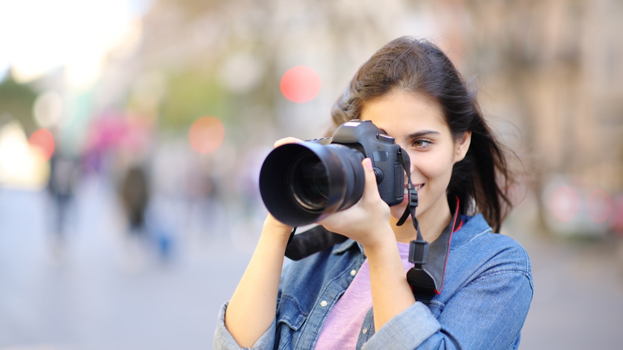 Woman photographing Eiffel Tower in Paris with DSLR camera.