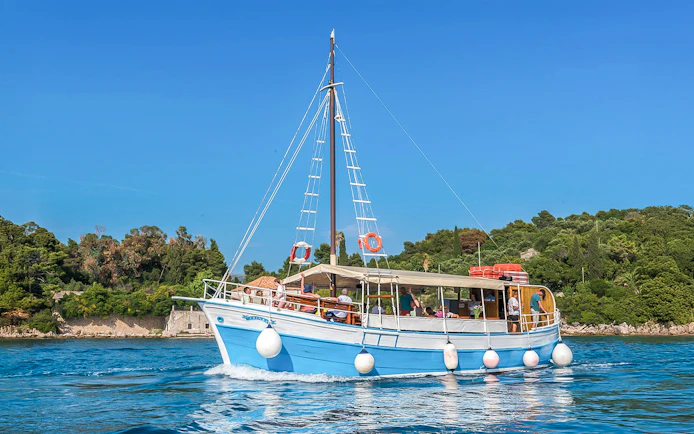 Boat cruising near Elaphiti Islands with passengers enjoying the view.