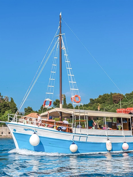 Boat cruising near Elaphiti Islands with passengers enjoying the view.