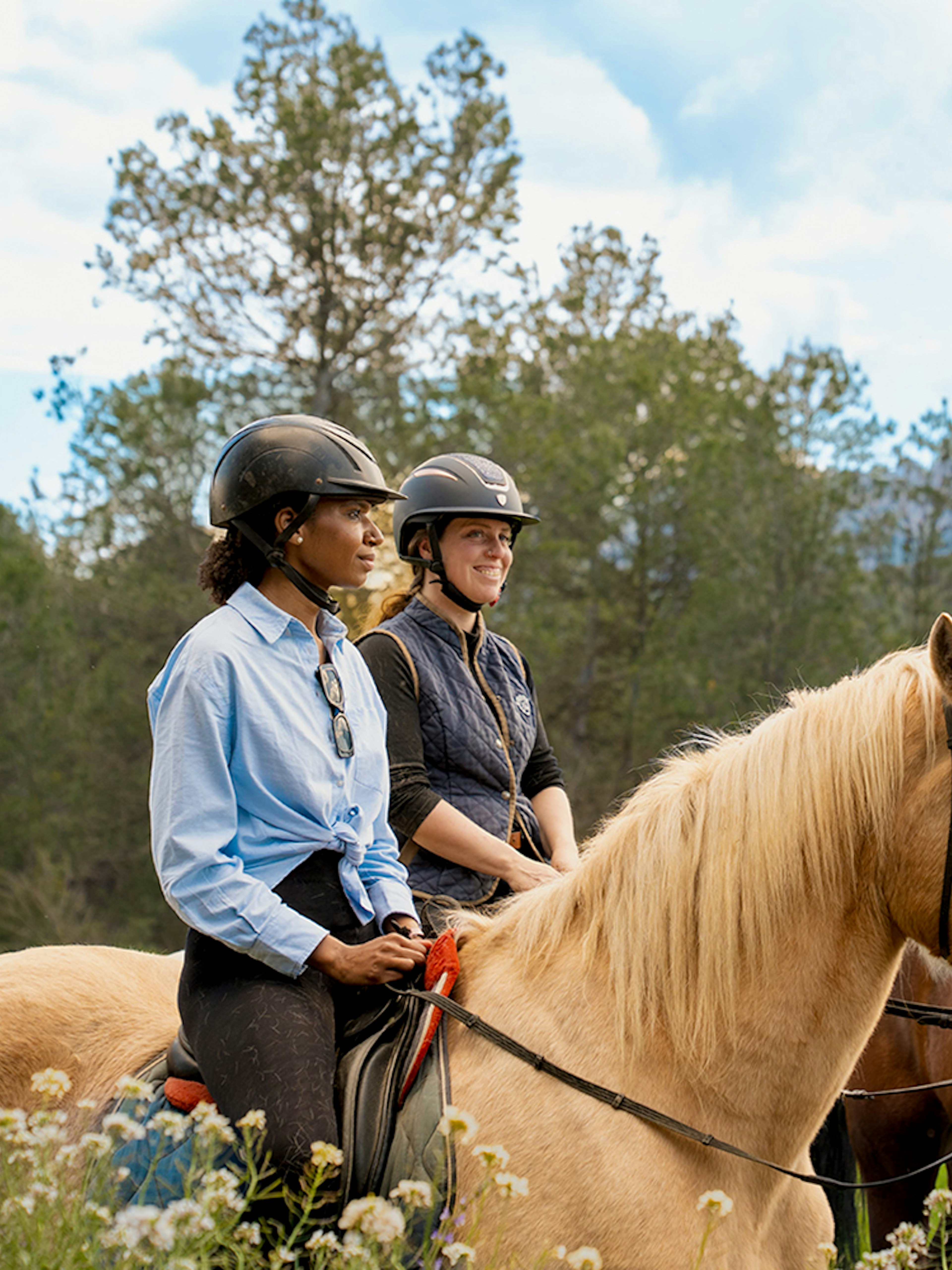 Tourists on horseback with a guide in Montserrat, surrounded by lush greenery.