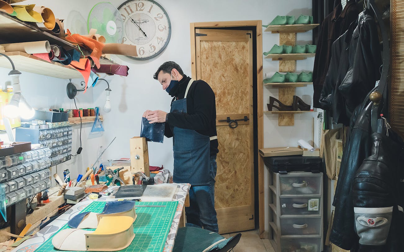 Artisan crafting leather goods in Ortigia workshop.