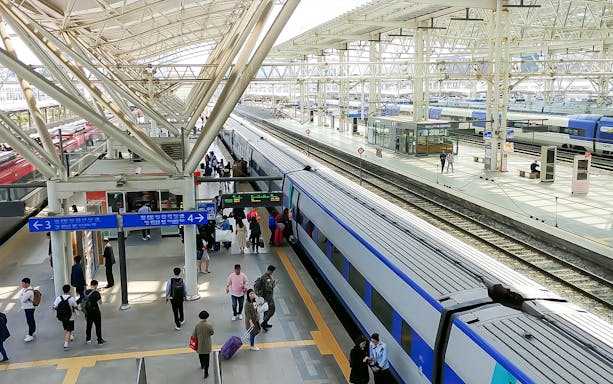 Passengers boarding a train at a busy station in South Korea, KORAIL Pass.