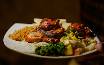 Traditional Middle Eastern dinner plate with grilled meats and salads during Abu Dhabi Evening Desert Safari.
