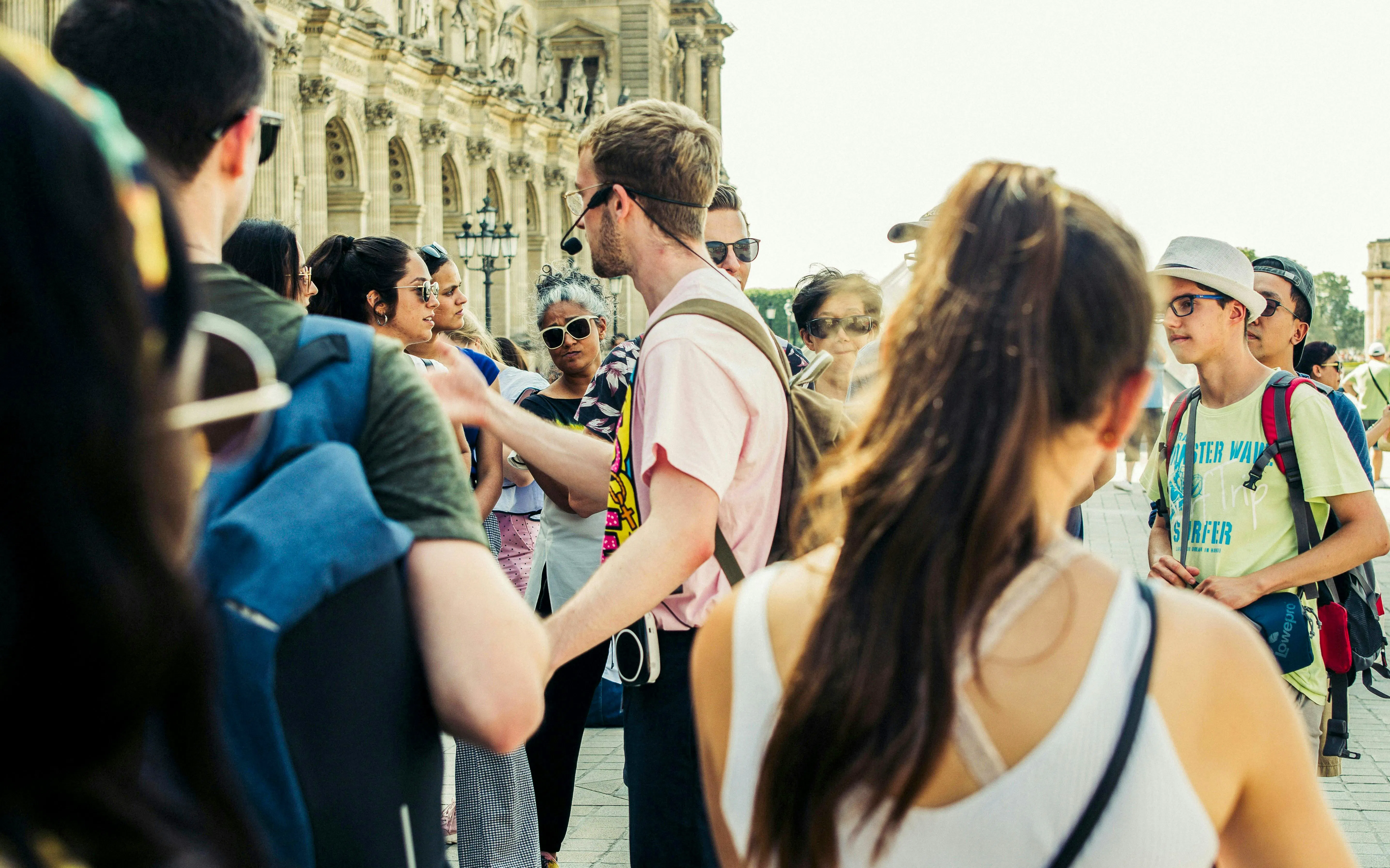 Tourists listening to a city guide near a historic building.