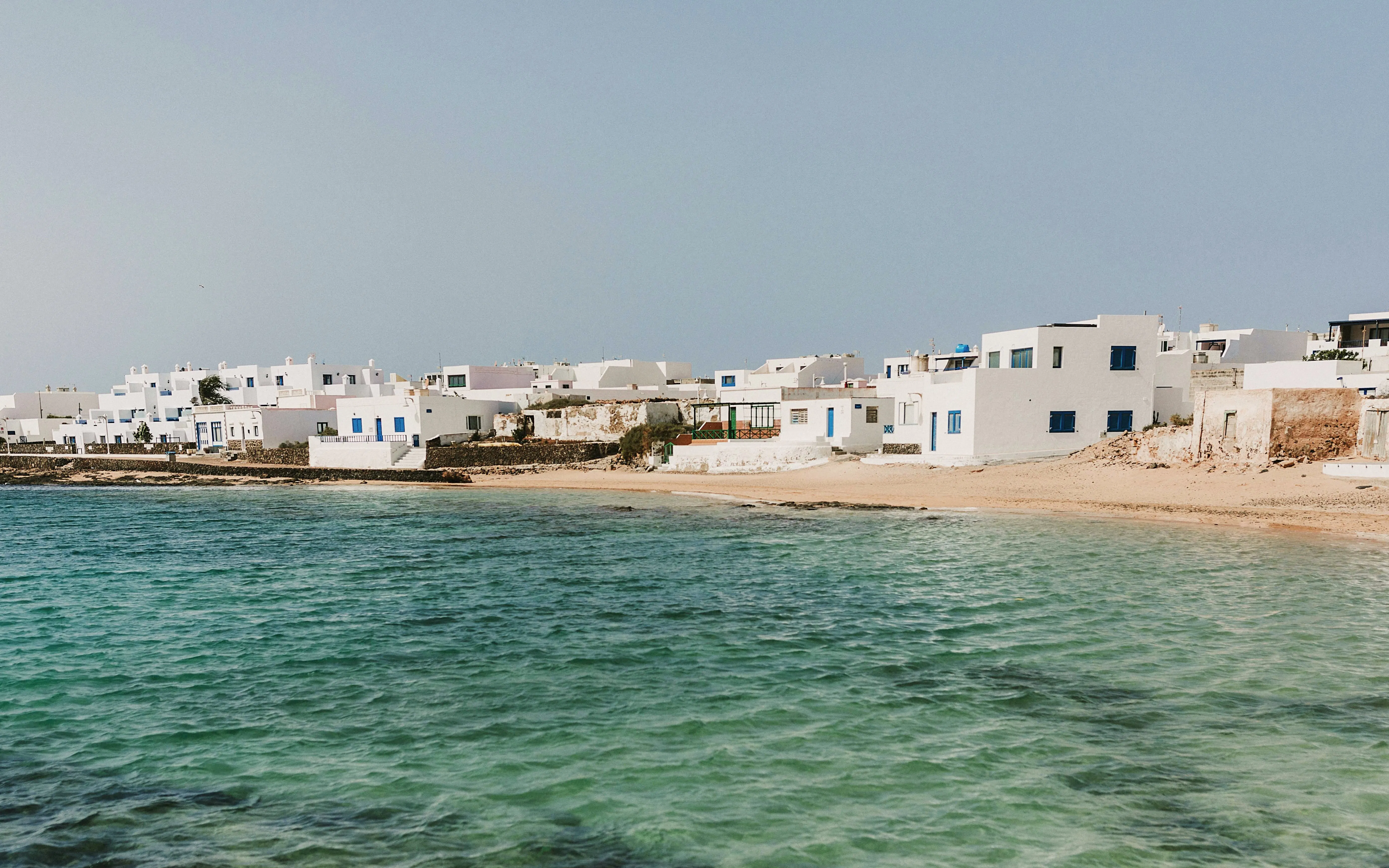 Coastal village of Caleta del Sebo with white buildings by the sea, La Graciosa, Canary Islands.