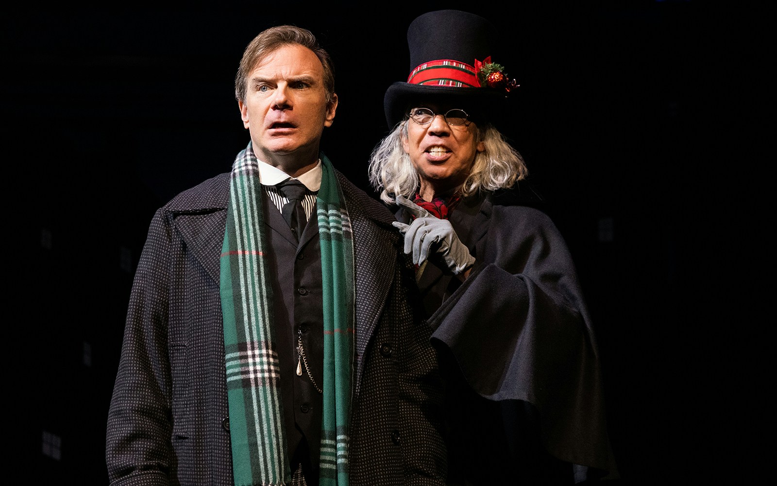 Two actors in Victorian attire performing in "A Sherlock Carol" stage play.