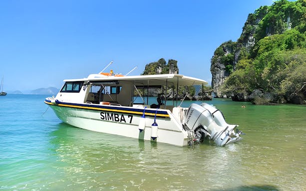 Speedboat anchored near limestone cliffs in Phang Nga Bay, Phuket.