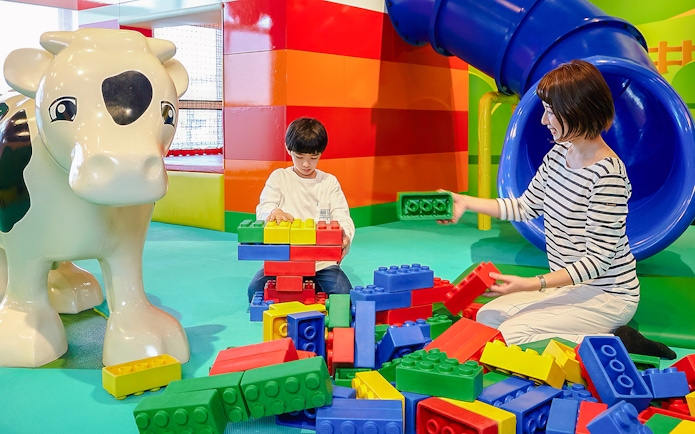 Child and adult building with large LEGO bricks at LEGOLAND Discovery Center Osaka.
