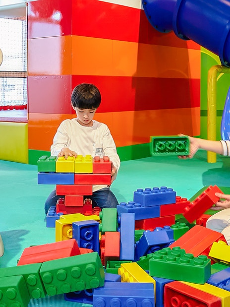 Child and adult building with large LEGO bricks at LEGOLAND Discovery Center Osaka.
