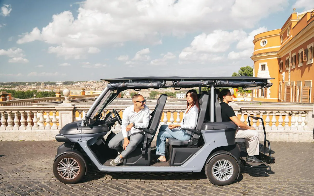 Golf cart with tourists on a panoramic tour in Rome, Italy.