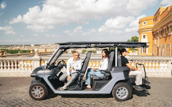 Golf cart with tourists on a panoramic tour in Rome, Italy.
