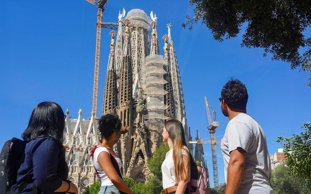 Visitors observing Sagrada Familia's intricate facade in Barcelona.