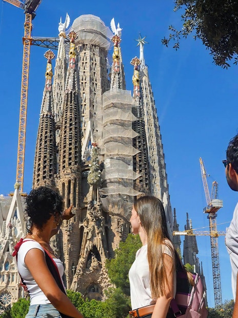 Visitors observing Sagrada Familia's intricate facade in Barcelona.