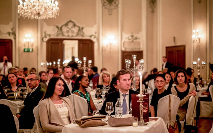 Audience enjoying a Mozart concert in Salzburg with musicians in period costumes in a historic venue.