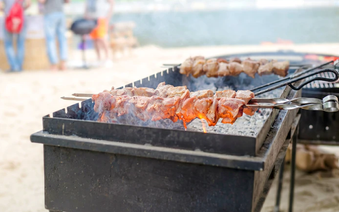 Barbecue skewers grilling on a beach in Côte Est de l'île Maurice.