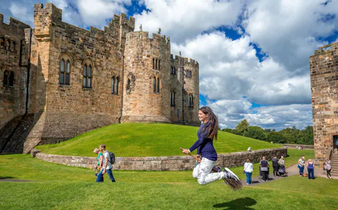 Woman practicing broomstick flying at Alnwick Castle, England.