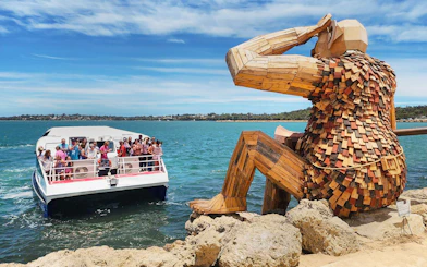 Boat tour near the Giants of Mandurah sculpture in Australia.