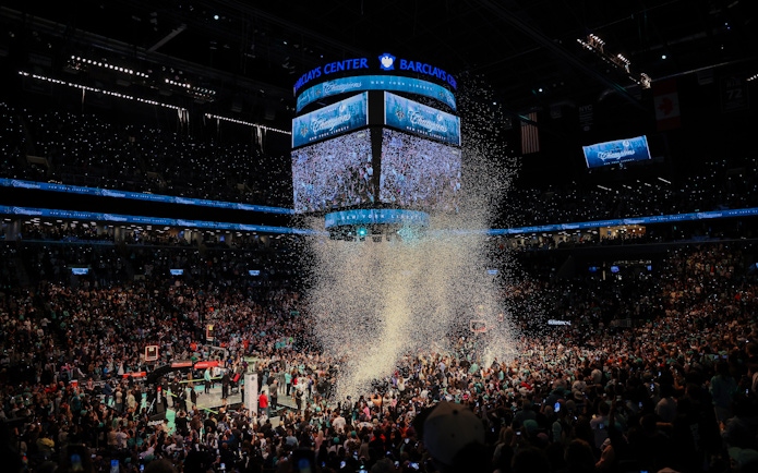 Fans celebrating at Barclays Center during New York Liberty basketball game.