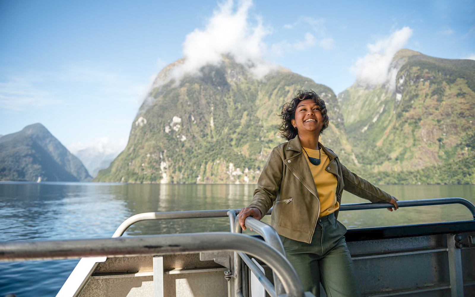 Person enjoying Doubtful Sound Wilderness Cruise with scenic mountain views from Te Anau.