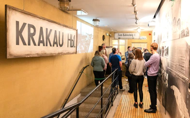 Visitors on a guided tour inside Oskar Schindler's Factory, Krakow, viewing historical exhibits.